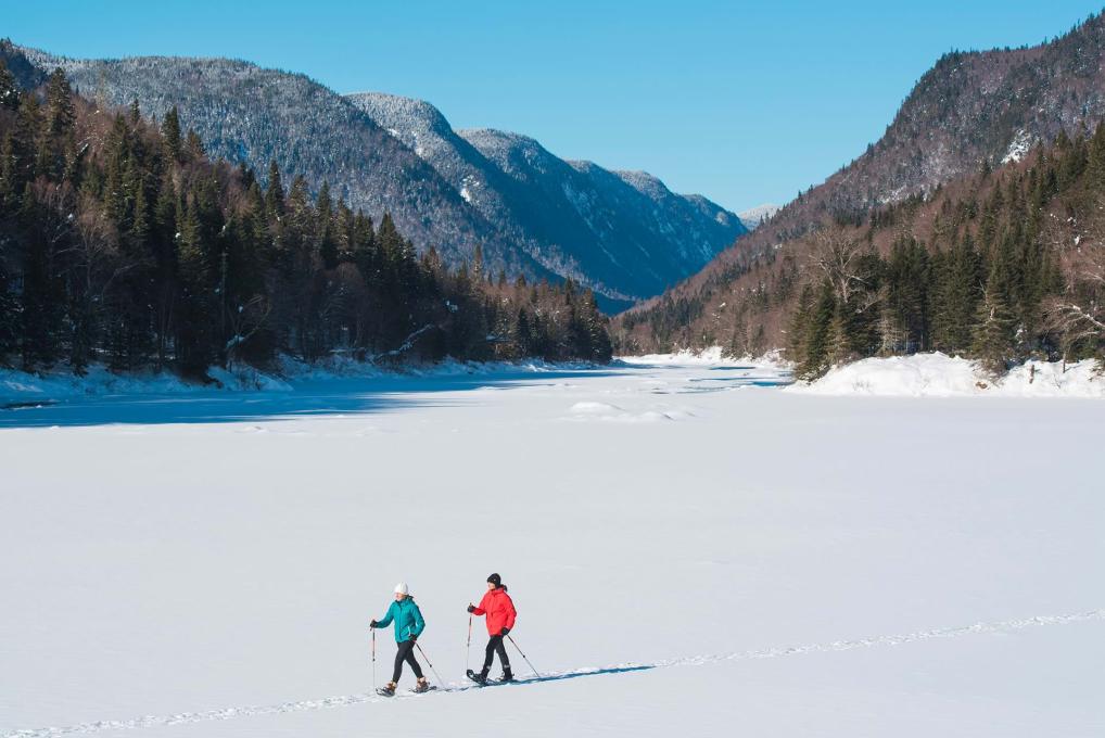 Two women are snowshoeing in the heart of the Jacques-Cartier Valley, in the Jacques-Cartier national park.