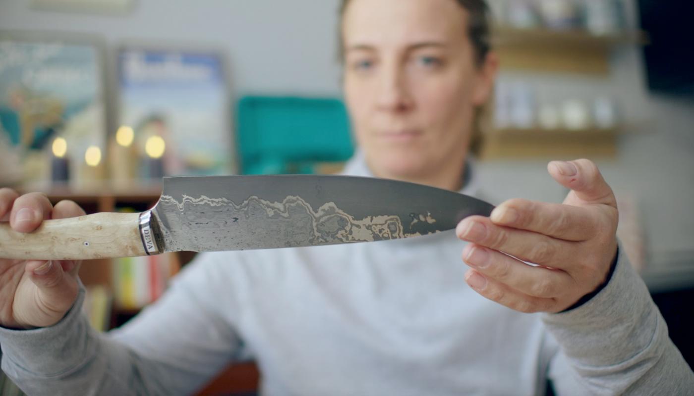 Amandine admire un couteau Deva fait à la main par un artisan-coutelier 
