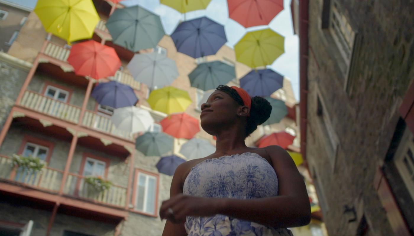 Oneika is walking under colorful umbrellas on Cul-de-Sac Street