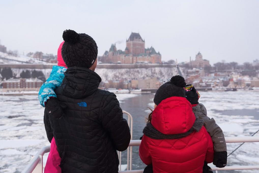 A family crosses the frozen St. Lawrence River aboard the Québec-Lévis Ferry in winter.