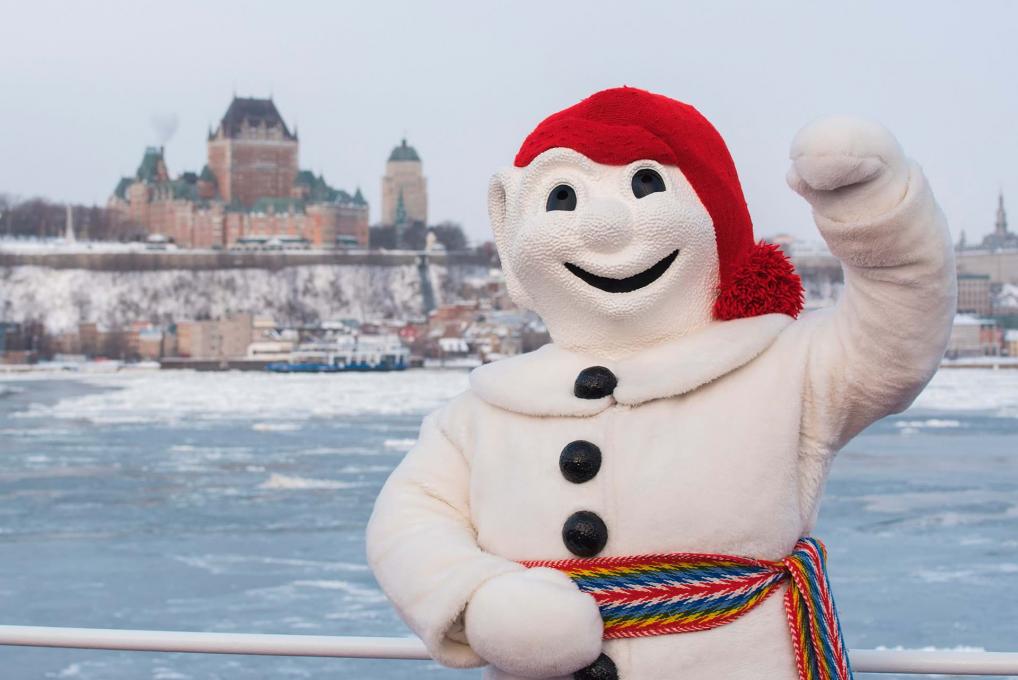 Bonhomme Carnaval proudly poses in front of the Château Frontenac, aboard the Québec-Lévis Ferry.