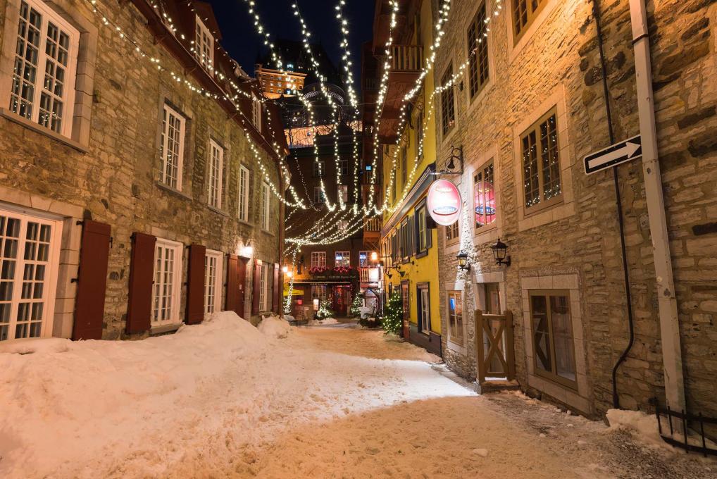 La rue du Cul-de-Sac enneigée dans le quartier Petit-Champlain avec des décorations de Noël et du temps des fêtes.