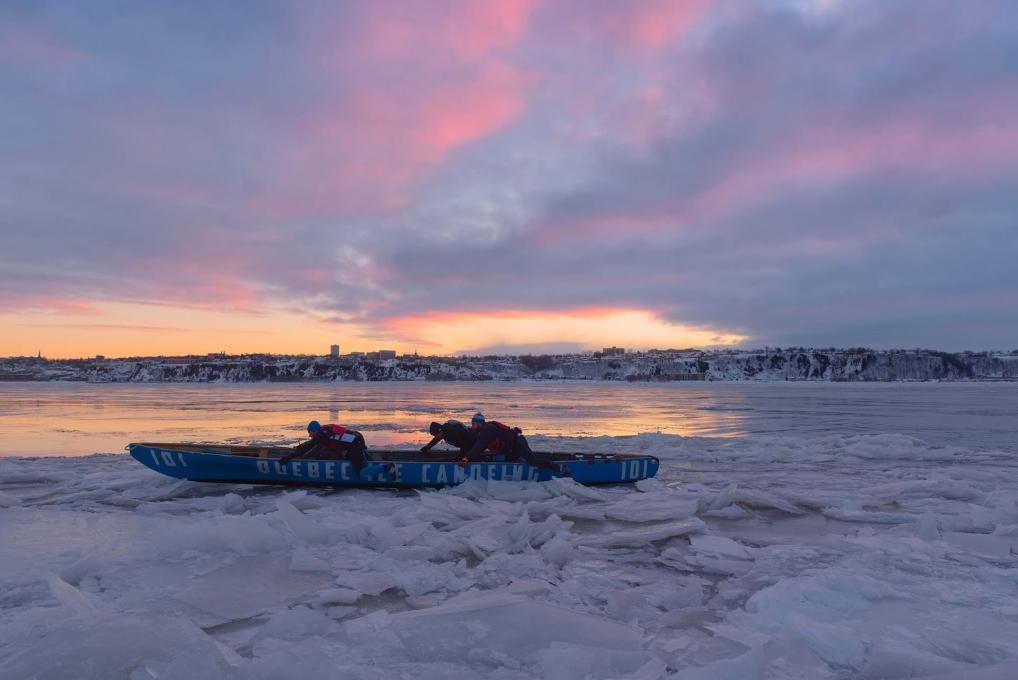 Quatre hommes en canot à glace sur le fleuve Saint-Laurent gelé, entre Québec et Lévis.