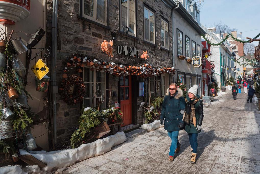 A couple walk in the street rue du Petit-Champlain, in winter.