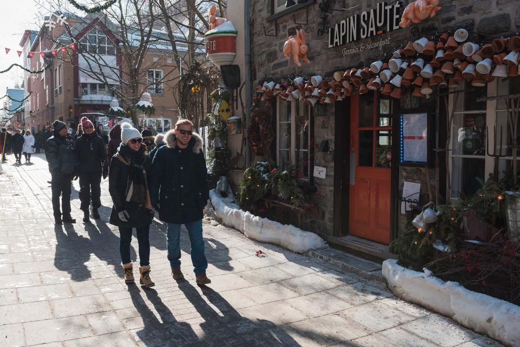 Several people walk in the rue du Petit-Champlain, near the restaurant Lapin Sauté, in Old Québec.
