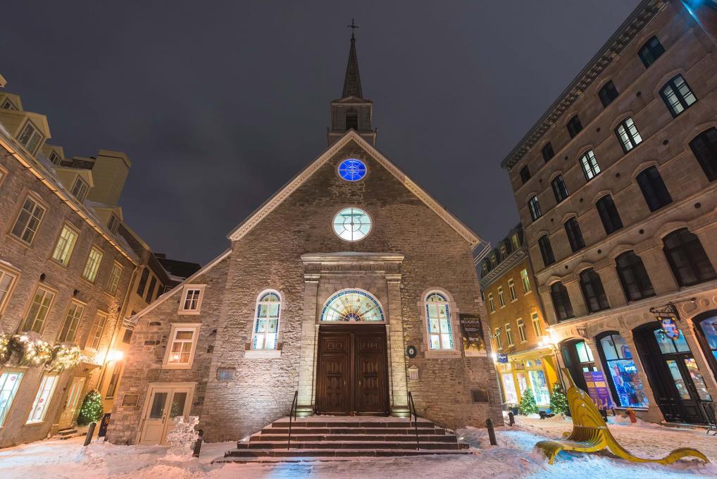 L'église Notre-Dame-des-Victoires illuminée en soirée, à Place-Royale, dans le quartier Petit-Champlain, en hiver.