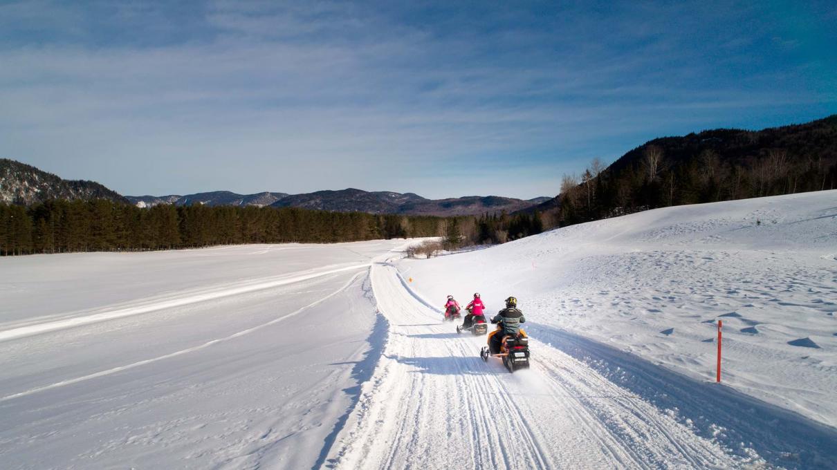 Snowmobilers riding in a field