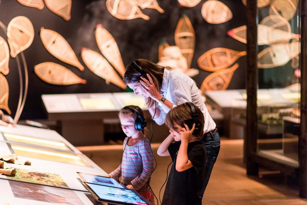 A mother and two children participate in an interactive exhibition at the Musée de la civilisation.