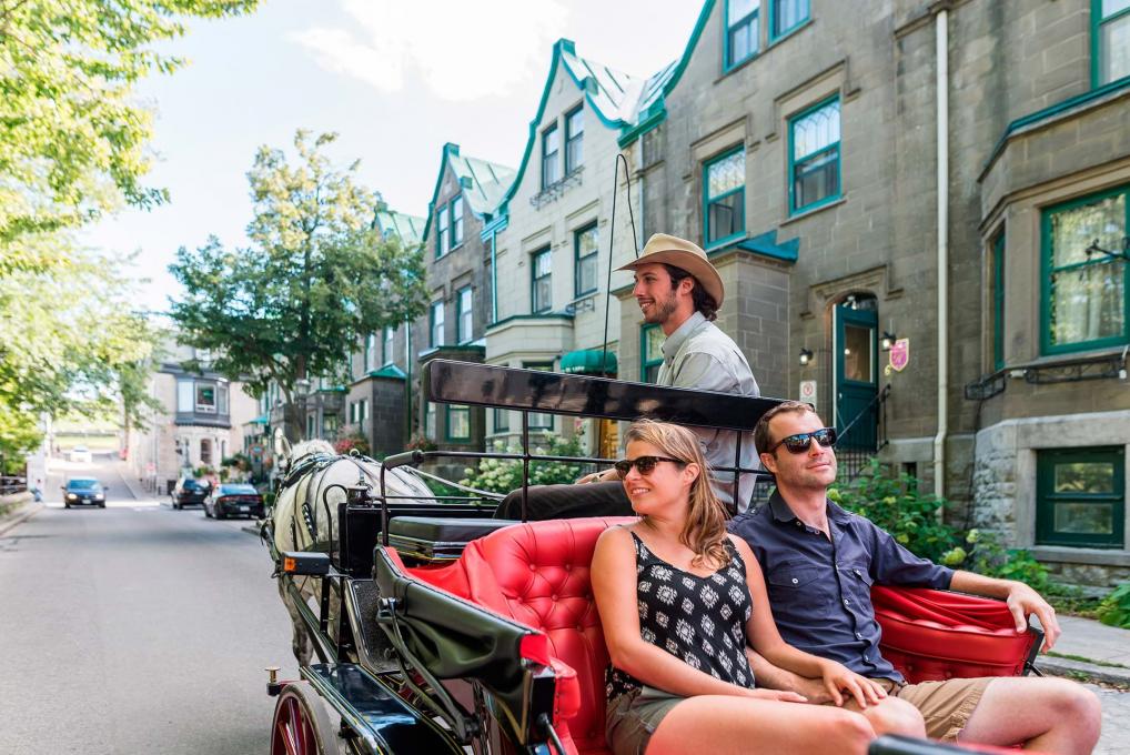 Un couple profite d'un tour guidé en calèche dans le Vieux-Québec, près du parc des Gouverneurs.