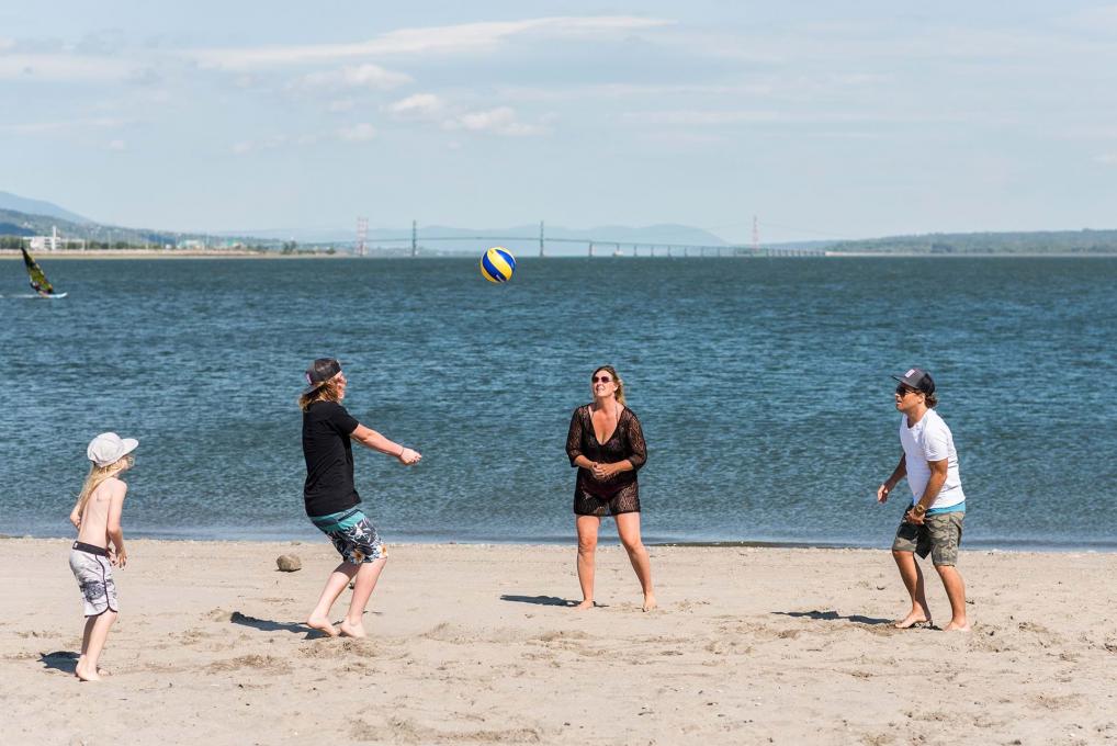 A family plays volleyball by the river, at Beauport Bay beach.