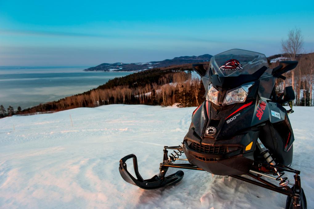 Snowmobile at the top of a mountain with a snowy background in Charlevoix