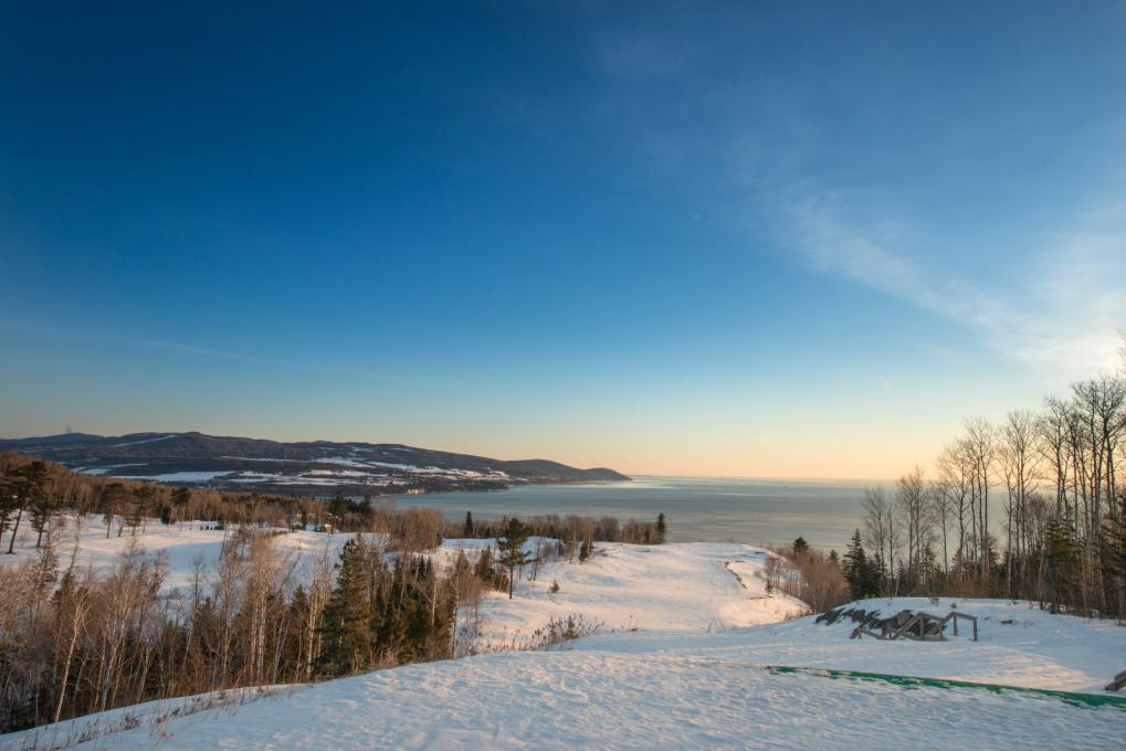 View of a snowy landscape and of the St. Lawrence River in Charlevoix