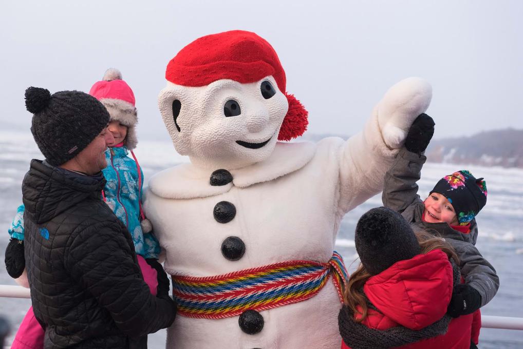 Le Bonhomme Carnaval rencontre une famille en hiver à bord de la Traverse Québec-Lévis.