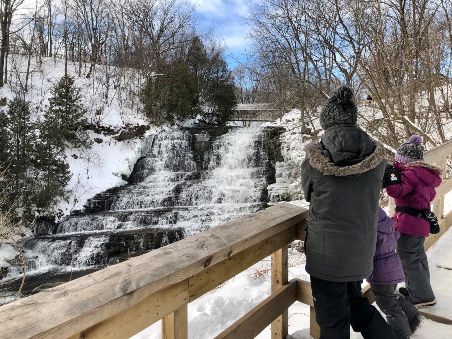 Famille devant une chute glacée au parc de la Rivière-Beauport