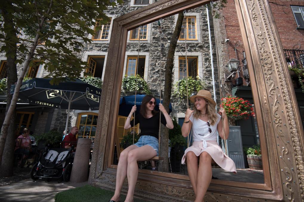 Deux filles se balancent sur une balançoire extérieure en été dans le quartier Petit-Champlain.