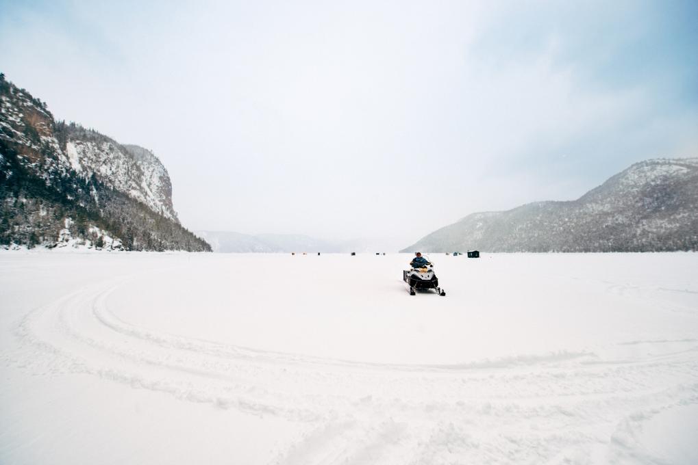 Snowmobilers passing through an ice fishing village in Saguenay-Lac-Saint-Jean,
