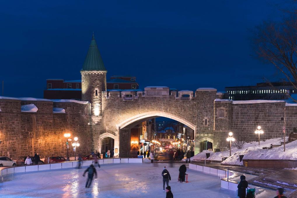 Porte Saint-Jean illuminée en soirée et patinage à la patinoire de la place D'Youville.