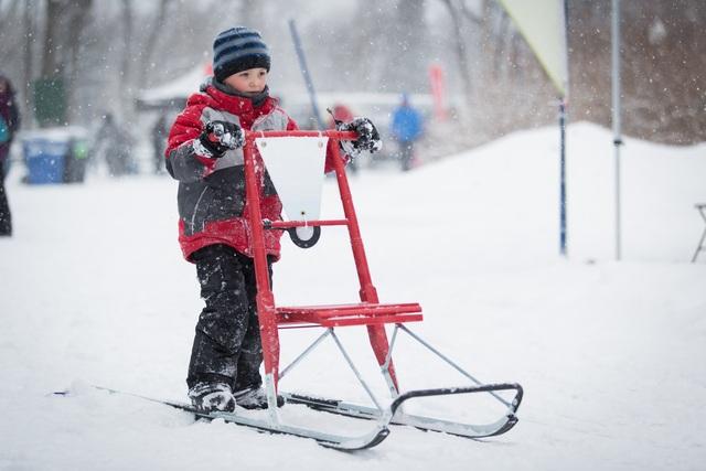 Enfant qui fait de la trottinette des neiges au Domaine Maizerets
