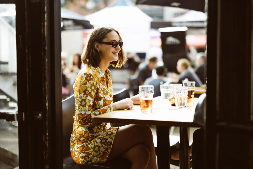 Femme qui prend un verre sur une terrasse