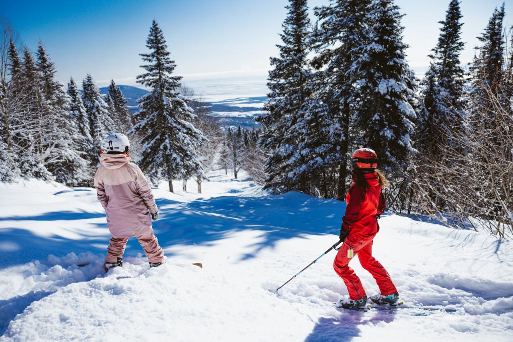 Skieurs face à une piste du Mont-Sainte-Anne