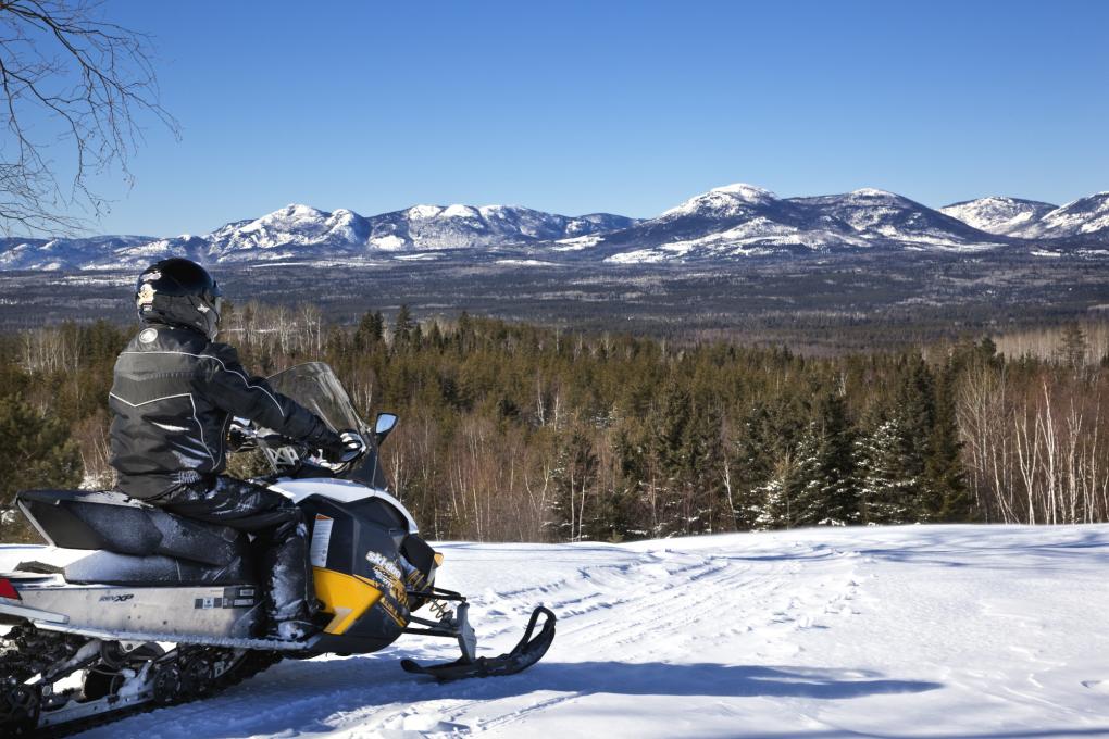 Snowmobiler overlooking the snowy landscape in Charlevoix
