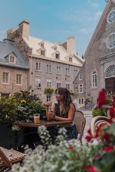 Femme attablée à un café sur la place Royale