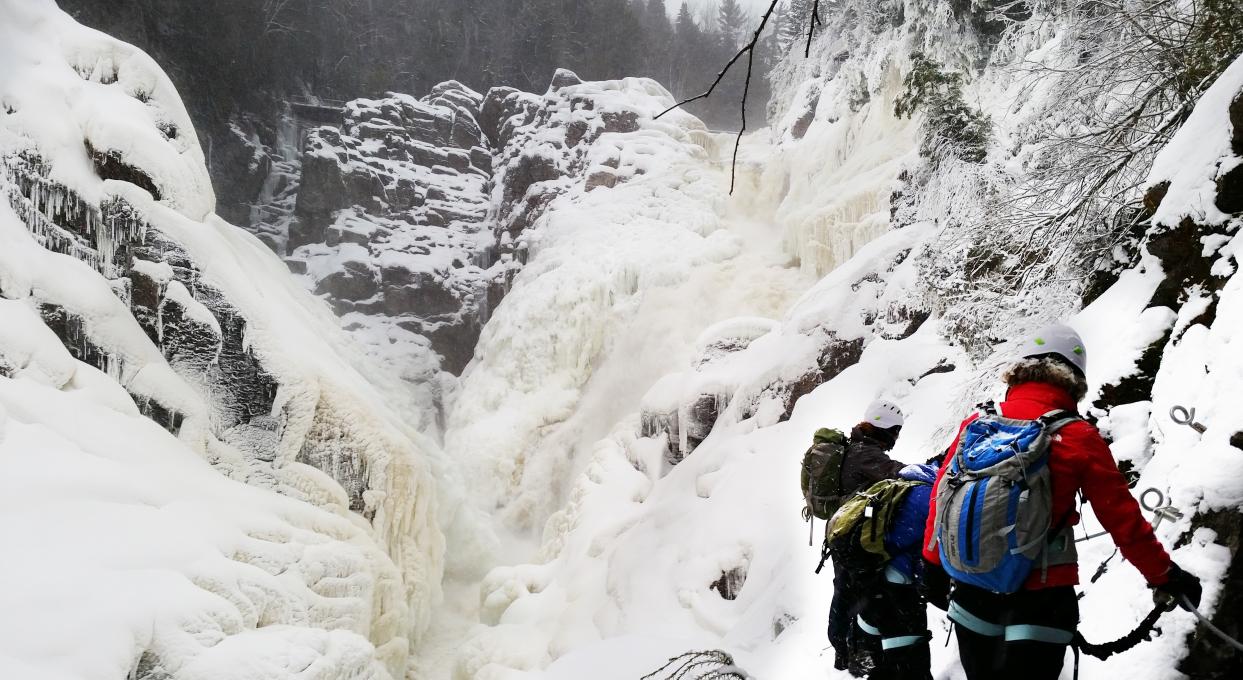 A group of people do the winter Via Ferrata activity at Canyon Sainte-Anne.