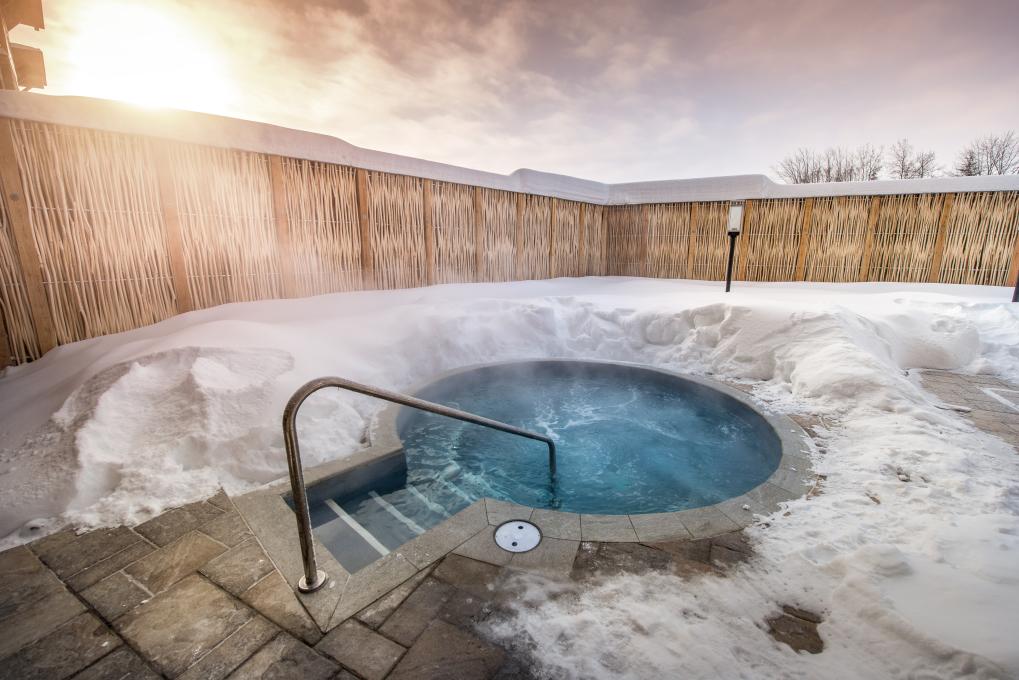 Vue d'un bain thermal extérieur en hiver à l'Aroma Spa du Village Vacances Valcartier.