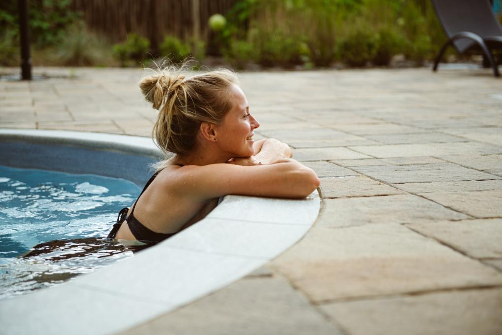 Une femme relaxe dans un spa extérieur au Aroma Spa du Village Vacances Valcartier.