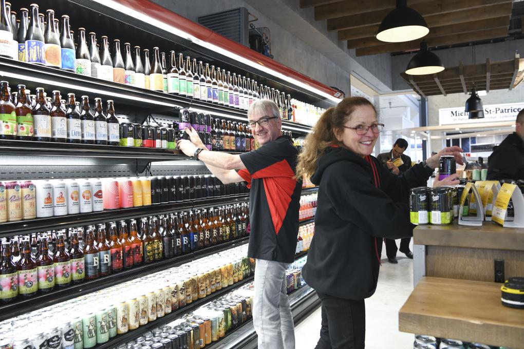 People are near a beer refrigerator at the Grand Marché in Québec.