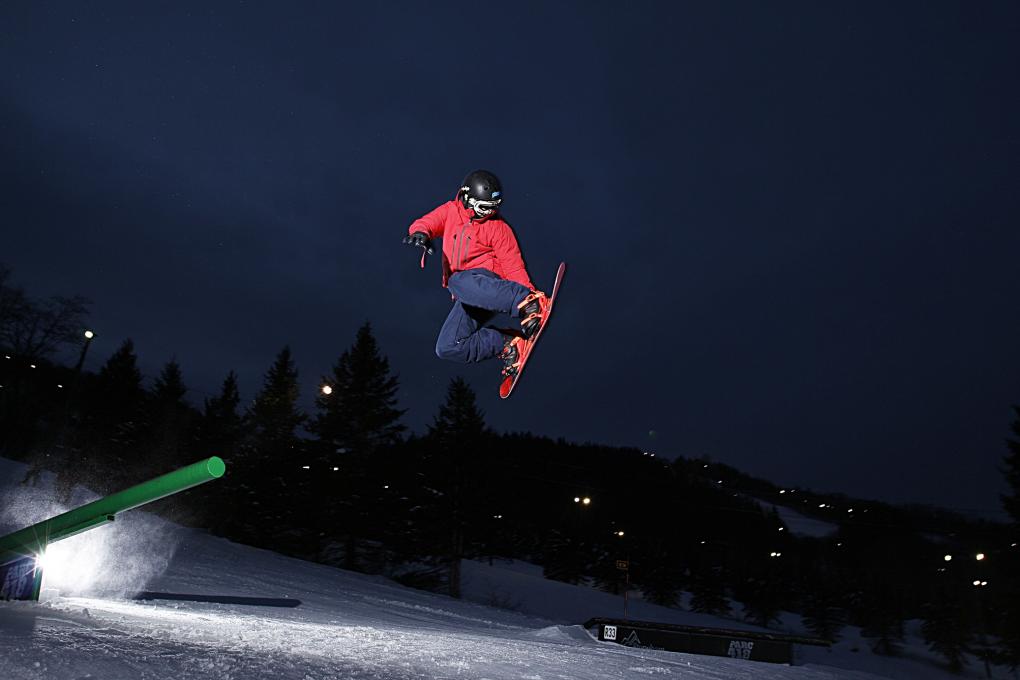 A young snowboarder at the Stoneham Ski Resort in the evening.