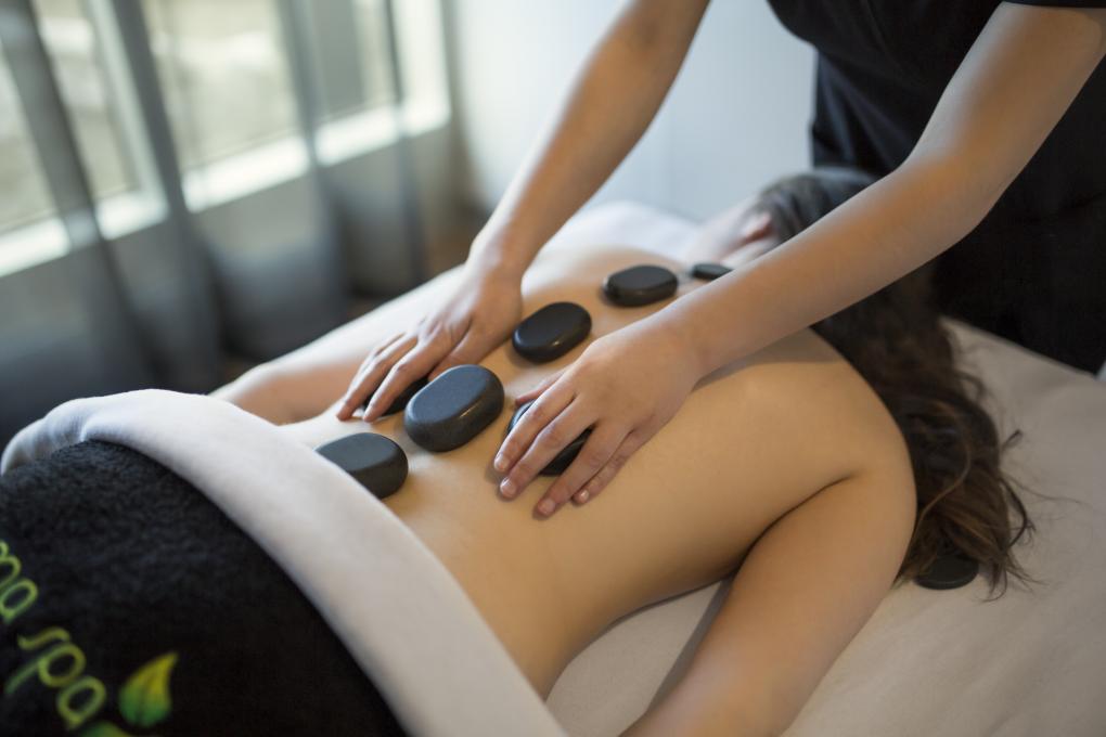 A woman receiving a hot stone massage at the Aroma Spa at Village Vacances Valcartier.