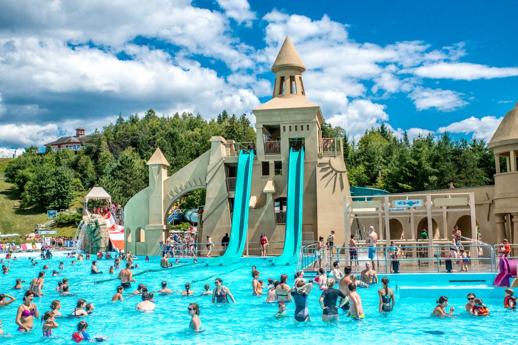 Glissades d'eau et piscine extérieure au Village Vacances Valcartier, en été.