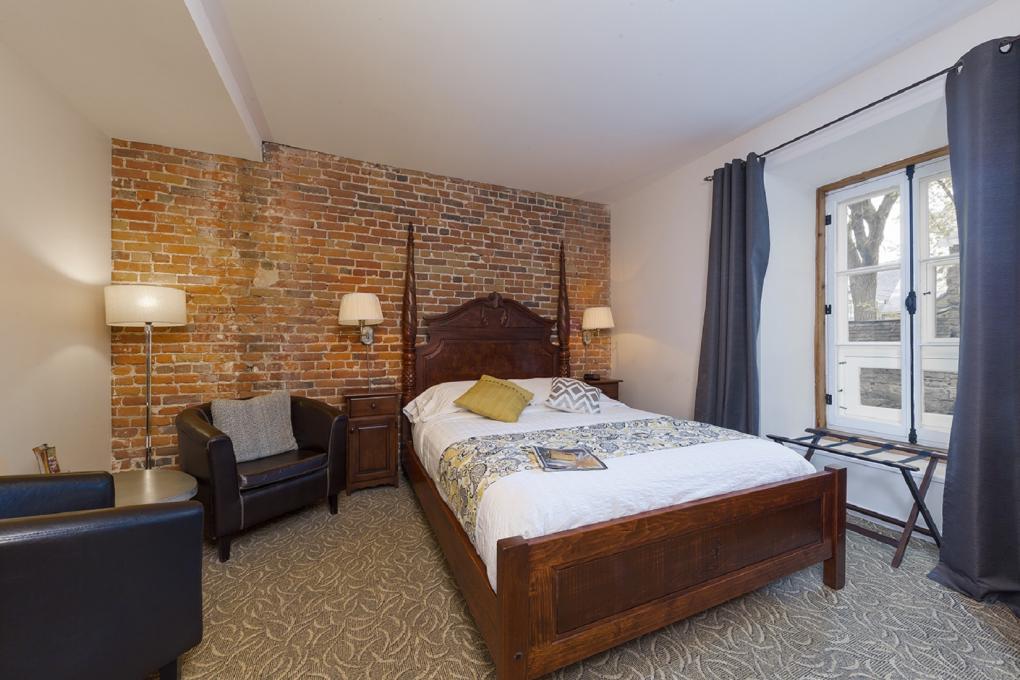 Le Coureur des Bois - Room with a wooden bed and brick wall