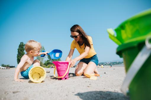 A mother and her child play to build a sand castle at the beach of Baie de Beauport.