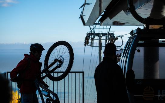 A cyclist boards a cable car with his bike in the Massif de Charlevoix.