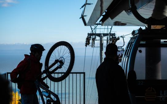 A cyclist boards a cable car with his bike in the Massif de Charlevoix.