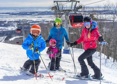 A family goes downhill skiing at Mont-Sainte-Anne.