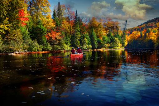 Deux personnes dans un canot sur une rivière en automne dans la Vallée Bras-du-Nord.