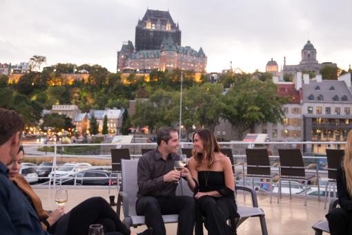 Croisières AML - Couple glass of wine in hand with Le Chateau Frontenac