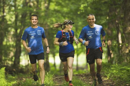 Three friends run in the forest on the trails of Station touristique Duchesnay.