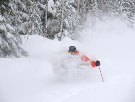 Un skieur fait une descente dans la neige poudreuse au Massif de Charlevoix.