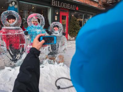 A family takes pictures with the ice sculptures in the Petit-Champlain district, during the Québec Winter Carnival.