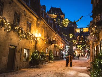 A couple in love walks in the evening in the rue du Petit-Champlain illuminated for Christmas and the holidays.