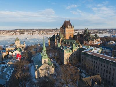 Vue aérienne du Vieux-Québec en hiver, avec le fleuve Saint-Laurent glacé, le Château Frontenac et l'église Holy Trinity. 