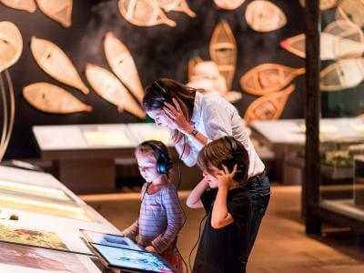 Une mère et deux enfants participent à une exposition interactive au Musée de la civilisation.
