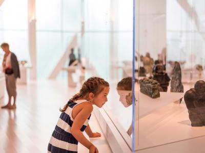 A young girl looks through a display case in an exhibition at the Musée national des beaux-arts du Québec.