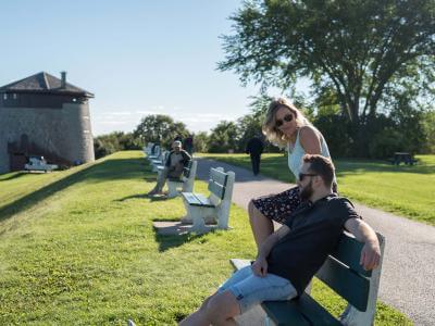 Couple sitting outside on a bench, near Martello Tower 1, on the Plains of Abraham.