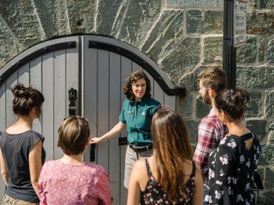 Un guide touristique avec un groupe de visiteurs devant les fortifications 