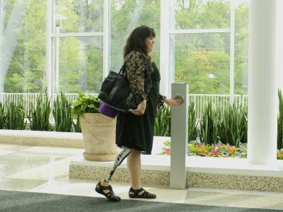 Personne handicapée utilisant un bouton d'ouverture de porte